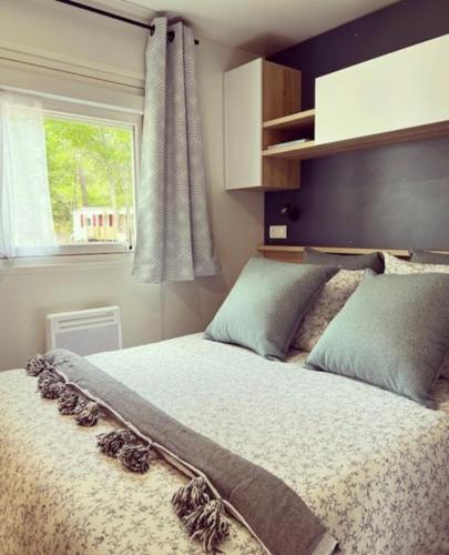 une chambre avec un grand lit avec une fenêtre dans l'établissement Charmant Mobile Home Cap-Ferret, à Lège-Cap-Ferret