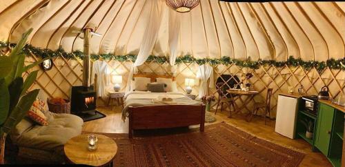 a room with a bed and a couch in a yurt at Yurtshire Eavestone Lake - Birch Yurt in Ripon