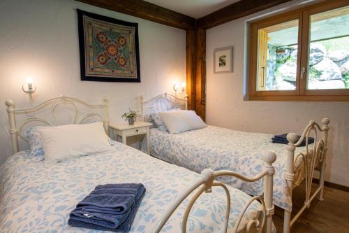 two twin beds in a room with a window at Chalet Grouse in Ayer
