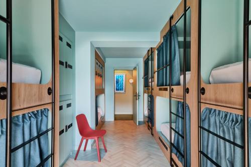 a red chair in a room with bunk beds at The Boc Hostels - Beach in Can Pastilla