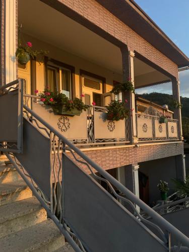 a building with a balcony with flowers on it at Nits Guesthouse in Kvariat'i
