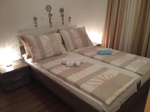 a bed with two pillows on it in a bedroom at Apartment Leptir in Podstrana