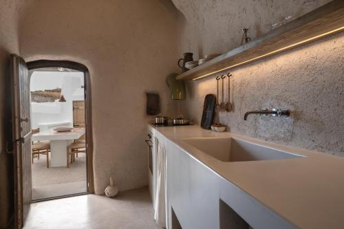 a kitchen with a sink and a table in the background at Kanava Cave Winery Villa in Mesaria