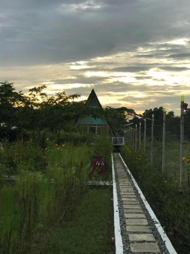 a small building in a field with a fence at Bed And Breakfast at Baba's Eco Farm in Manaoag