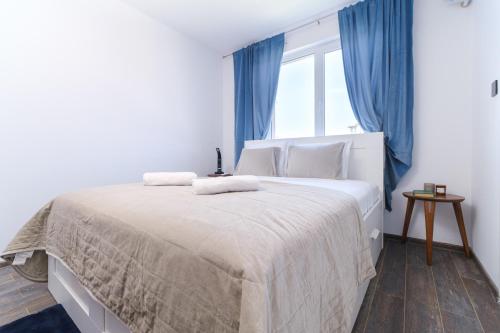 a bedroom with a large white bed with blue curtains at Serene Luxe Oasis Retreat on the Outskirts by Flat Mаnager in Plovdiv