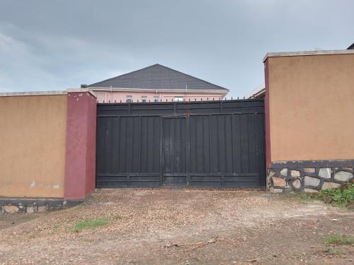 a black gate in front of a house at Wana Guest House in Rubirizi