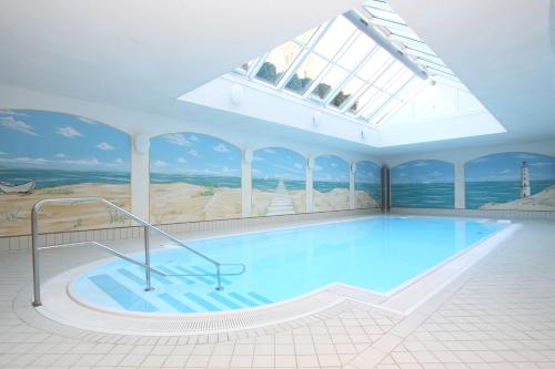 a large swimming pool in a building with a skylight at Akzent Hotel Am Burgholz in Tabarz