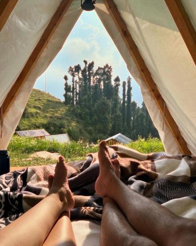 a group of people laying on a bed in a tent at Driftters in Chakrāta