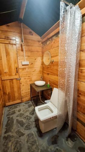 a bathroom with a toilet and a table in it at Driftters in Chakrāta