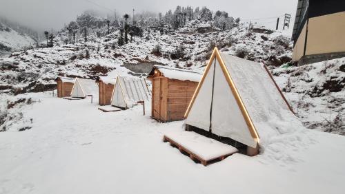 a group of tents covered in snow on a mountain at Driftters in Chakrāta