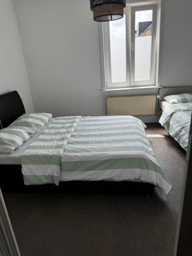 une chambre avec deux lits et une fenêtre dans l'établissement Appartement De panne, à La Panne