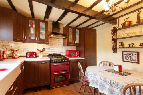 a kitchen with a red stove top oven next to a table at Rosehip Cottage Period home, Bingham, Nottingham in Bingham