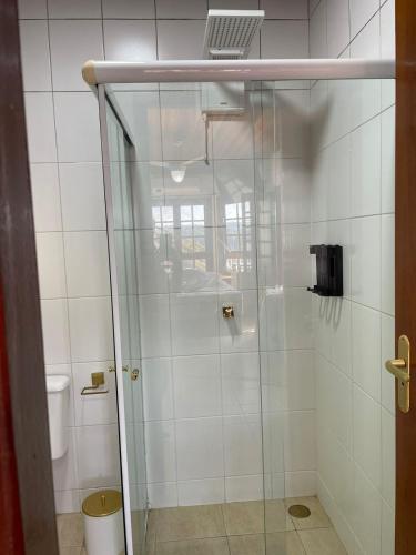 a shower with a glass door in a bathroom at Chalé das Águas in Igaratá