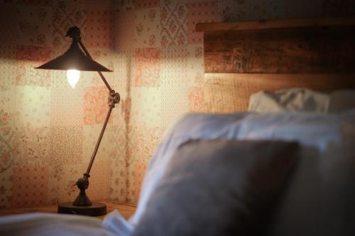 a lamp sitting on a table next to a bed at Marmotte Mountain Manor in Chamonix-Mont-Blanc