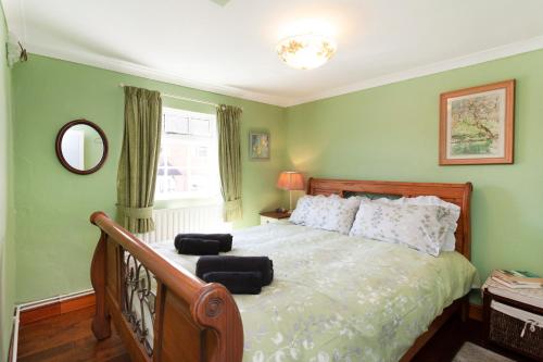 a bedroom with a bed with two black ottomans on it at Rosehip Cottage Period home, Bingham, Nottingham in Bingham
