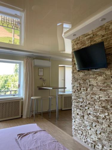 a bedroom with a stone wall with a tv on a wall at Квартира в центрі Світлі мрії Avenue Myru35 in Chernihiv