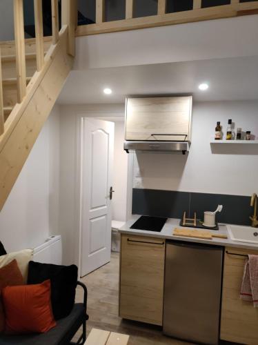 une cuisine avec un évier et une cuisinière four supérieur dans l'établissement Studio indépendant, à Nogent-lʼArtaud