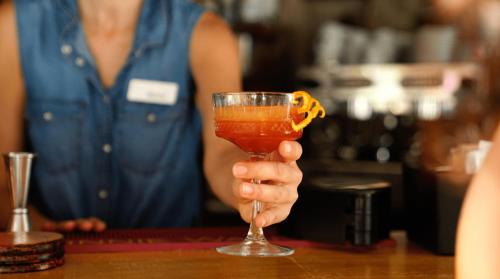 a person holding a glass with an orange drink at Lakki Village in Aegiali