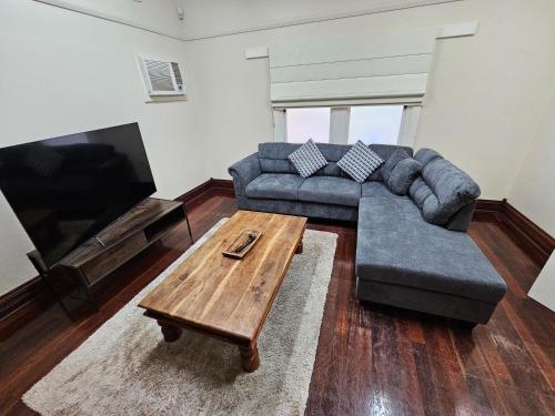 a living room with a couch and a coffee table at Central to town - Vintage and cosy entire home in Geraldton
