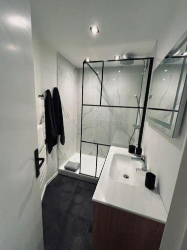 une salle de bain blanche avec une douche et un lavabo dans l'établissement LOUBATIERE, Superbe Appartement rénové au Coeur de la Station, à Montgenèvre