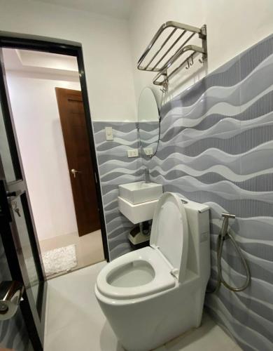 a bathroom with a toilet and a sink at Marketpoint Hotel in Mogpog