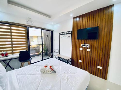 a bedroom with a bed and a desk and a tv at Marketpoint Hotel in Mogpog