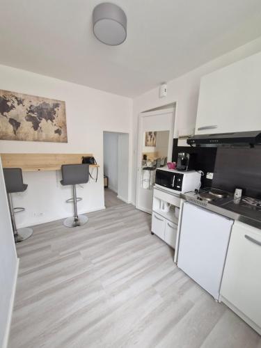 a kitchen with white cabinets and a counter top at La famille in Angoulême