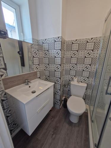 a bathroom with a white toilet and a sink at La famille in Angoulême