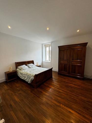 a bedroom with a bed and a wooden floor at Chez Kiki in Châtillon-sur-Seine