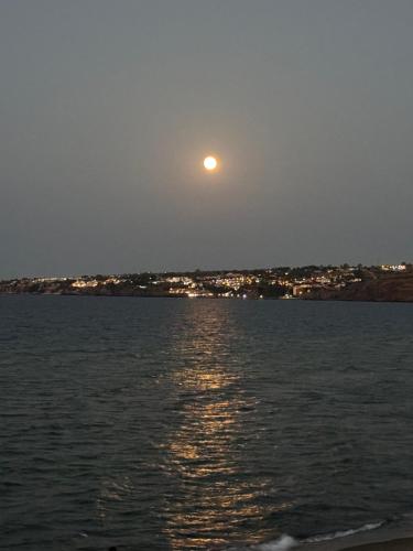 a moon rising over a body of water at Paradiso fronte Mare in Agnone Bagni