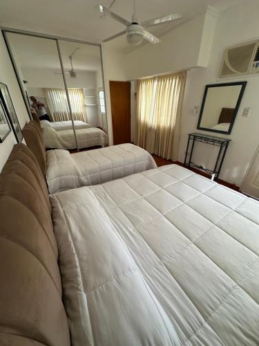 a bedroom with two beds and a large mirror at LPR Express EZE Airport in Monte Grande