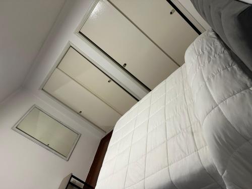 a bedroom with a bed and a window on the ceiling at LPR Express EZE Airport in Monte Grande