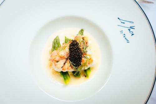 a plate of food with shrimp on a white plate at Le Yaca Saint-Tropez in Saint-Tropez