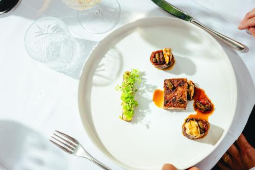 a white plate with food on a table at Le Yaca Saint-Tropez in Saint-Tropez