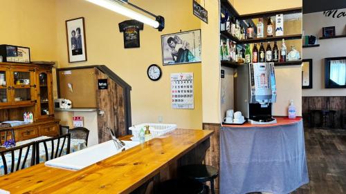 a bar in a restaurant with a kitchen with a sink at Yufuin Tabinokura in Yufuin