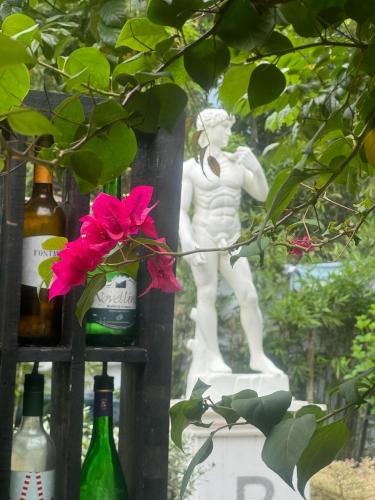 a statue of a man standing next to wine bottles at Bed And Breakfast at Baba's Eco Farm in Manaoag