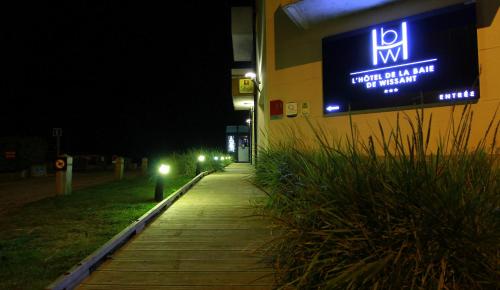 a sign on the side of a building at night at Logis- Hôtel de la Baie de Wissant & Appartements in Wissant