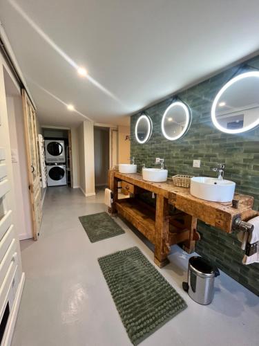 a bathroom with two sinks and two mirrors at La Grange d'Annalys in Granges-Narboz