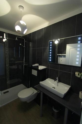 a bathroom with a toilet and a sink and a tub at Logis- Hôtel de la Baie de Wissant & Appartements in Wissant