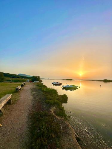 a sunset on a lake with boats in the water at Villa Neni - Key to Villas in Valledoria