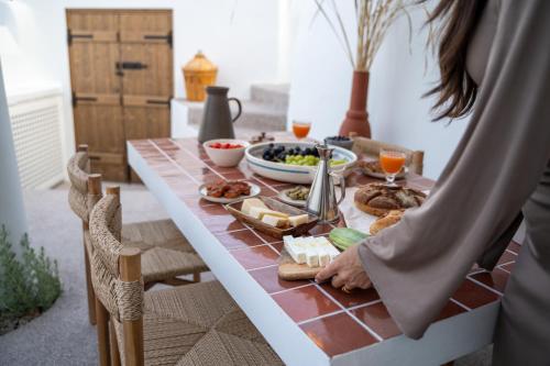 a woman standing at a table with food on it at Kanava Cave Winery Villa in Mesaria