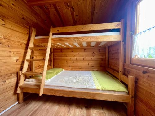 a room with two bunk beds in a log cabin at Domki u Haliny in Przewłoka