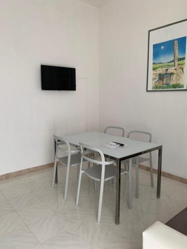 a table and chairs in a room with a tv at VENTINOVE Apartments in Otranto