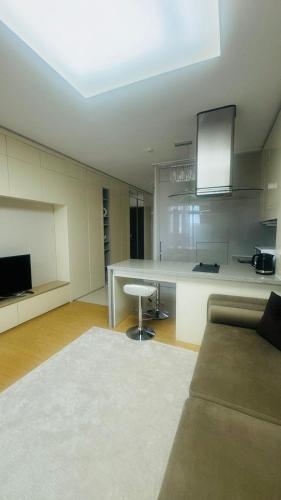 a living room with a couch and a kitchen at Apart - Highvill, Хайвилл in Promyshlennyy