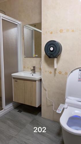 a bathroom with a sink and a toilet and a mirror at 粨倉文旅 in Xiluo