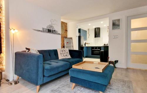 a living room with a blue couch and a table at Molly Marine - Bespoke 2 Bedroom Courtyard Apartment - 1 Minute From Brighton Pier in Brighton & Hove