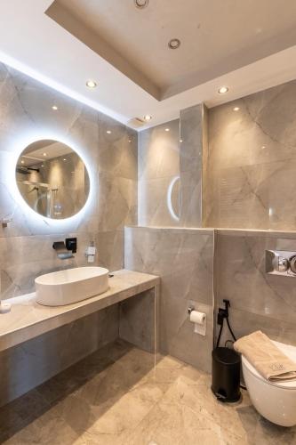 a bathroom with a sink and a toilet and a mirror at VSP RENT ROOMS FUeGO in Sikia