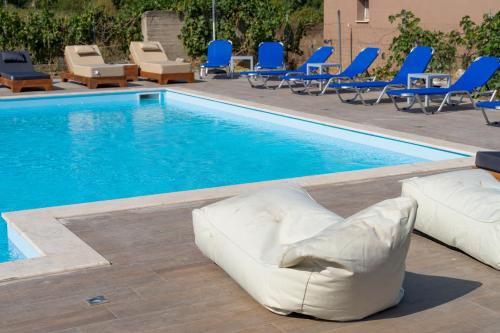 a pool with chairs and a white couch next to it at VSP RENT ROOMS FUeGO in Sikia