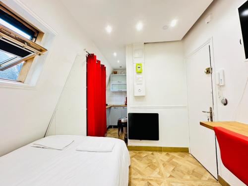 - une petite chambre avec un lit et un rideau rouge dans l'établissement Pretty Central flat in Paris, à Paris