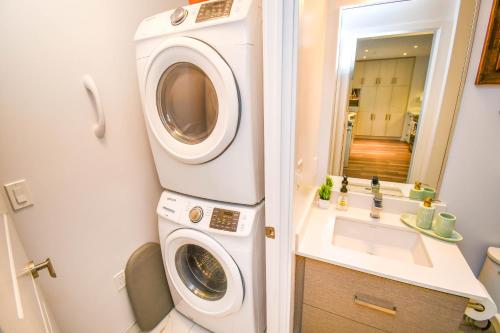 a washing machine in a bathroom with a sink at Golf Paradise Pool Fire Pit King Bed in Innisfil